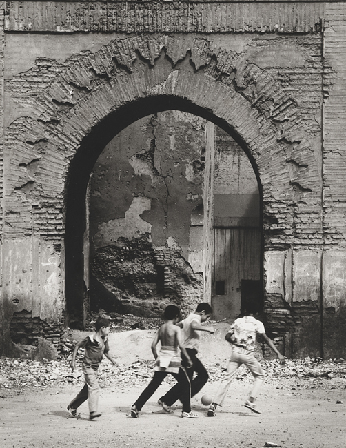 [boys playing in front of ruin]